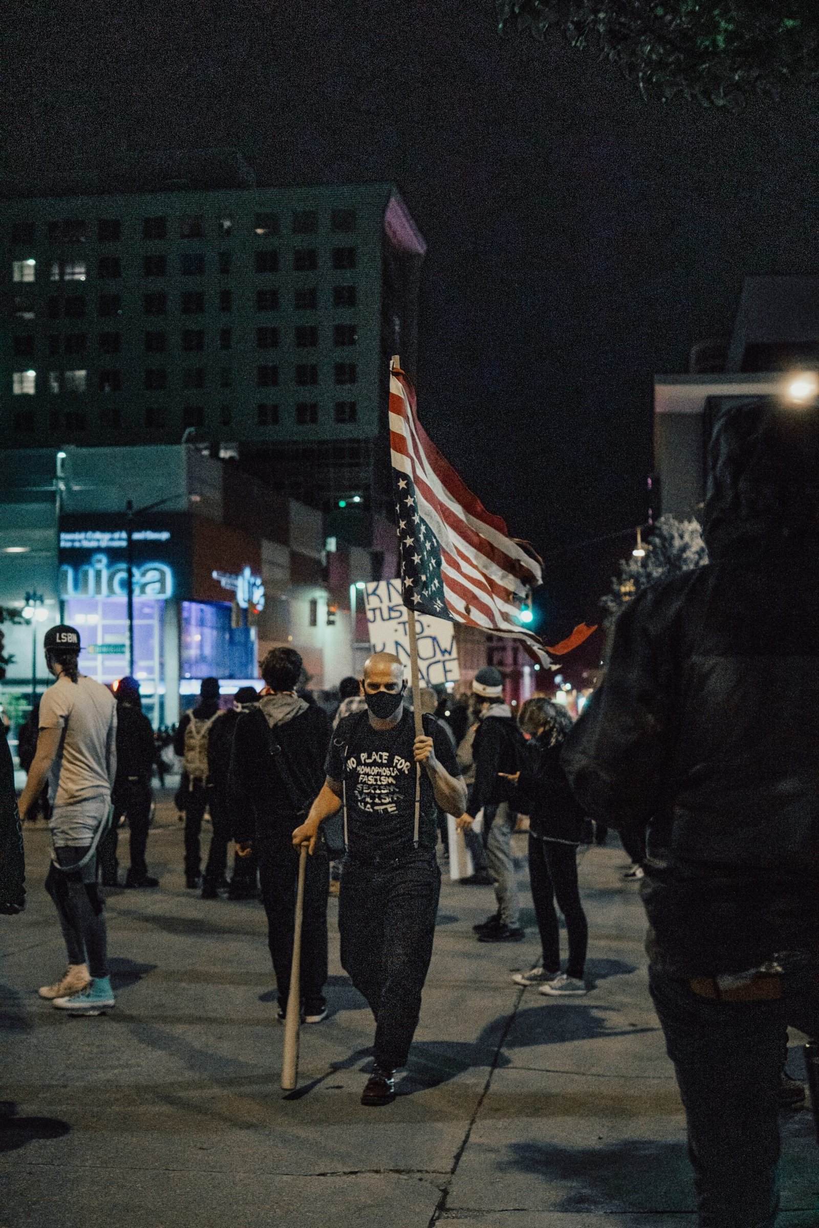 Crowd of people protesting along a city street at night
