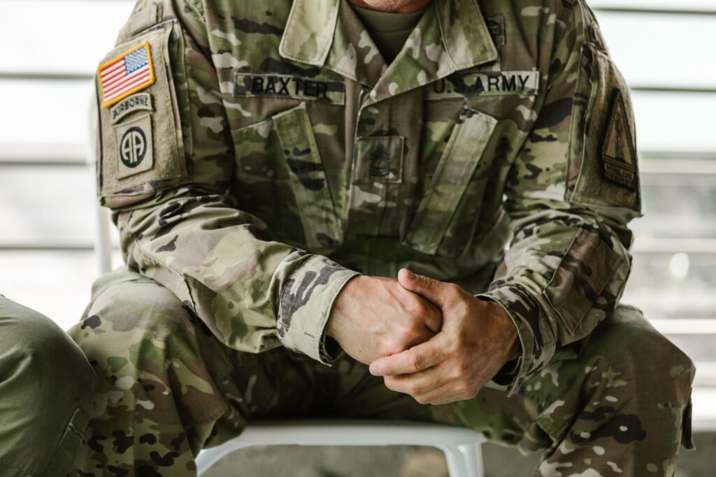 Close-up of a service member's hands clasped over a camouflage uniform