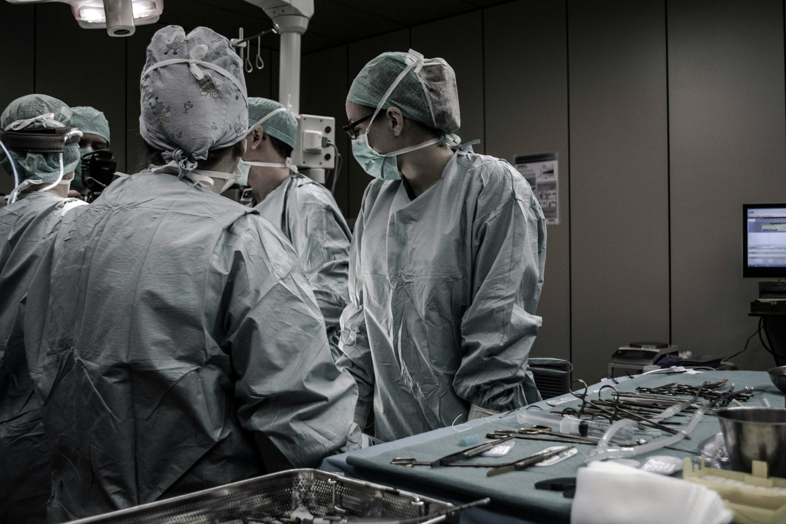 Medical professionals wearing surgical attire and working together in an operating room.