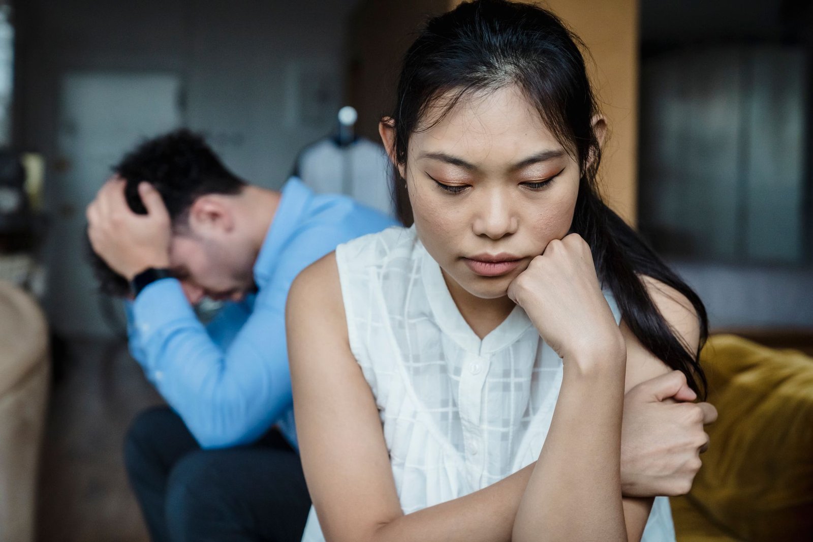 Two people sitting apart in silence, tension between them.